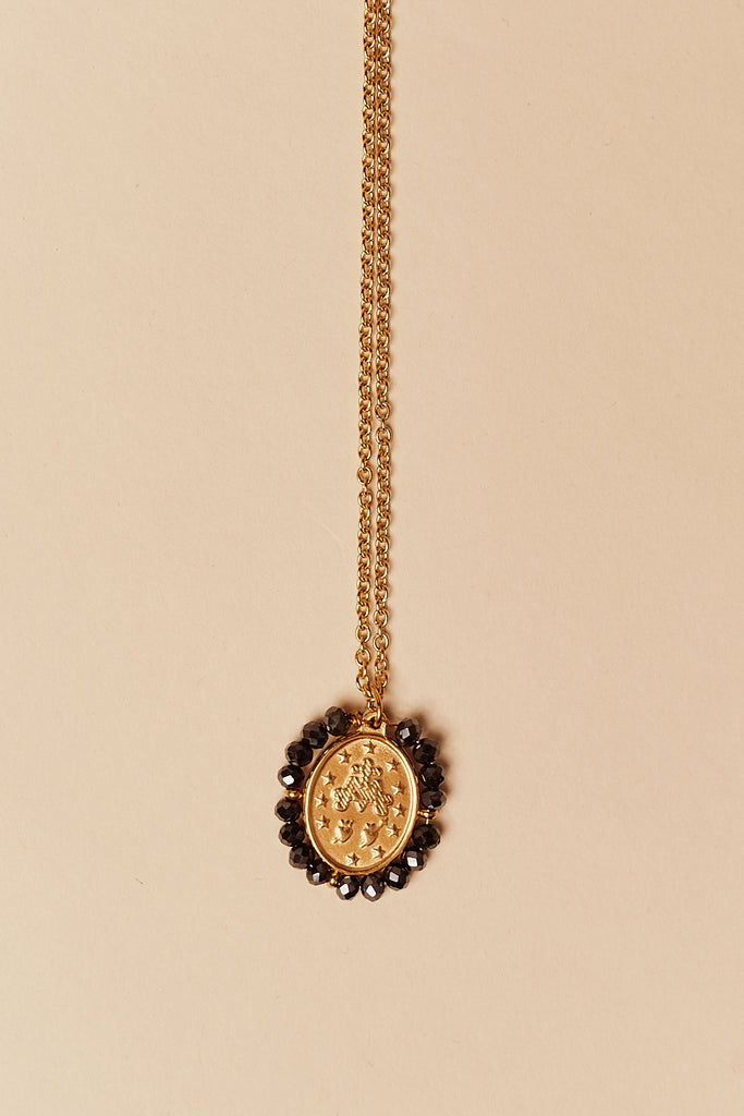 Feine goldfarbene Kette mit ovalem Medaillon eingerahmt von Shiny-Black-Steinen
