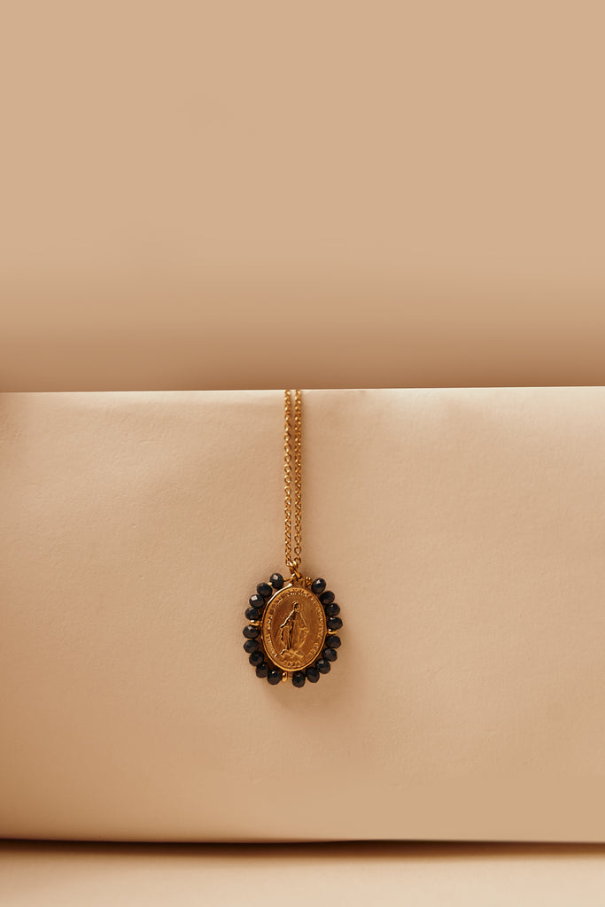 Feine goldfarbene Kette mit ovalem Medaillon eingerahmt von Shiny-Black-Steinen